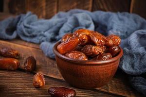 Dried date fruit in bowl on wooden background. Delicious dates fruit photo