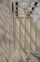 Sunlight and shadow on surface of white wooden roof truss structure under construction in vertical frame, construction and architecture concept photo