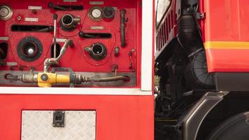manómetro y palanca de válvula con bomba de seguridad contra incendios de alta presión en la vista lateral del camión de bomberos rojo foto