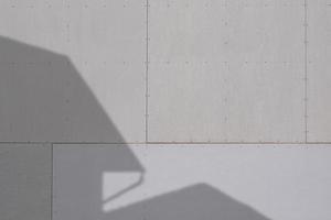 Sunlight and shadow of house structure on gray gypsum wall surface photo