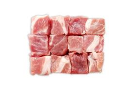Goulash de cerdo de carne cruda en cubitos, corte aislado sobre fondo blanco. foto