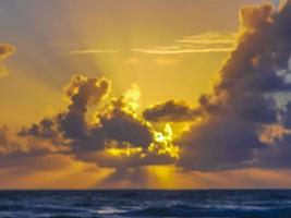 Golden colorful sunrise sunset with sunbeams tropical beach Tulum Mexico.