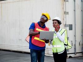 ingeniería supervisor hembra sudáfrica piel negra hablar discutir capataz gerente empresa oficina fábrica mirar trabajo tableta computadora cuaderno informe información importación exportación contenedor logística carga foto