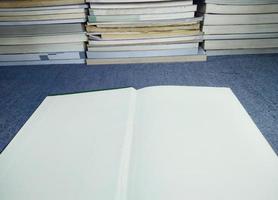 empty white book with a stack of books giving ideas exam preparation data recording photo