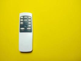 white remote control placed on a yellow background remote control concept  technological advancement  feel awesome photo