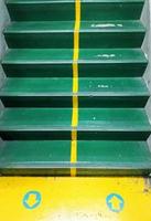 Concrete stairs are painted green and There are yellow arrows indicating the way up and down, giving ideas, rules. photo