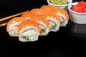 Sushi sets Uramaki, California, Philadelphia, rolls on a white plate. Menu for restaurants, cafes. On a dark reflective background. photo