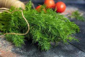 Fresh vegetables for salad. Tomatoes and lettuce, cucumbers with zucchini and cabbage with dill. Spring harvest, benefits and vitamins. On a dark background. photo