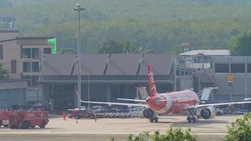 phuket, tailandia 29 novembre 2019 - compagnia aerea low cost asiatica airasia al terminal dell'aeroporto in manutenzione. vista sul piazzale dell'aeroporto di phuket. video