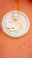 lion in circular shape bas relief art on orangel wall photo