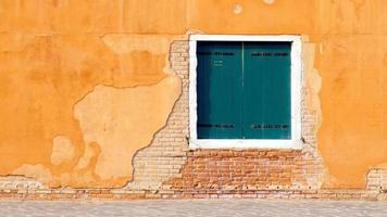 green Window on yellow and brick wall building photo