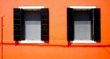 casa de dos ventanas en burano en la pared naranja foto