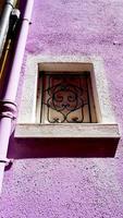 Window frame in Burano on purple color wall photo
