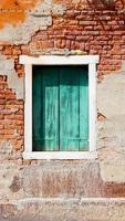 ventana y antiguo muro de descomposición en Venecia, Italia foto