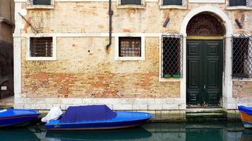 canal and boats with ancient brick wall house photo