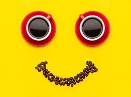 Cup of coffee and coffee beans with smile face concept, Top view on yellow background. For morning happy concept photo