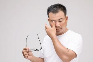 concepto de irritación ocular, retrato de un hombre asiático en postura de ojo cansado, irritación o problema con su ojo. tiro del estudio aislado en gris foto