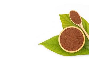 Pile of Cocoa powder in wooden spoon and green leaf  isolated on white background photo