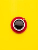 Top view black coffee or Americano in red cup isolated on yellow photo