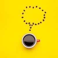 Top view black coffee or Americano in red cup and coffee beans on yellow photo