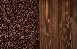 granos de café tostados y textura de madera. vista superior textura de granos de café marrones para fondo y uso de papel tapiz foto