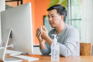 Man using hand sanitizer gel to clean his hand, Work from home and Healthy concept photo