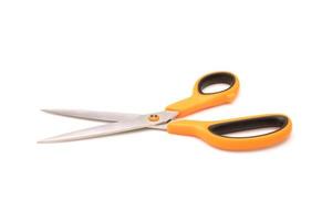 New scissor with orange and black color on handle isolated on white photo