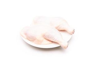 Raw chicken thighs in white dish isolated on white photo