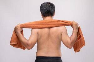 hombre de cerca sosteniendo una toalla para frotar el cuerpo seco después de la ducha. a la toalla mojada usada puede ser la dermatitis en el concepto del cuerpo foto