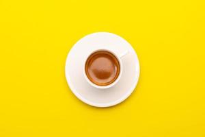 Top view espresso coffee in white cup on yellow photo