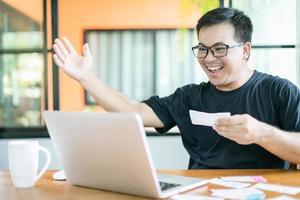 concepto de lotería del gobierno ganador, gente tailandesa revisando el resultado de la lotería del gobierno de tailandia en una computadora portátil y acción muy feliz después de ganar foto