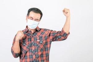 pasó el concepto de mala situación, el hombre asiático con mascarilla protectora en acción de alegría, victoria o muy feliz aislado en gris foto