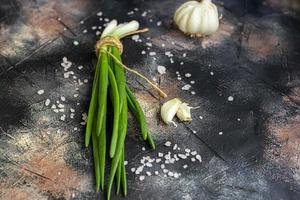 Green onions for salad or fritata. Spring harvest, benefits and vitamins. On a dark background. photo