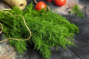 Fresh vegetables for salad. Tomatoes and lettuce, cucumbers with zucchini and cabbage with dill. Spring harvest, benefits and vitamins. On a dark background. photo