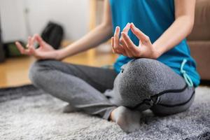 Woman practicing yoga at home from online classes after work. stress relief, muscle relaxation, breathing exercises, exercise, meditation. photo