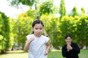 Asian family with both father, mother and daughter having fun in the garden of the house happily photo