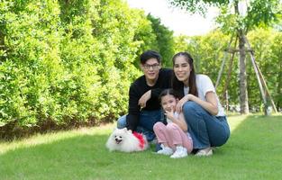 familia asiática con padre, madre e hija divirtiéndose alegremente en el jardín de la casa foto