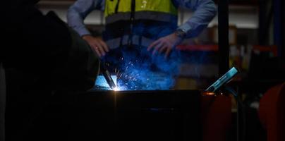 Welder working welding metal with Engineer to closely control the work in order to obtain the quality according to the prescribed form. photo