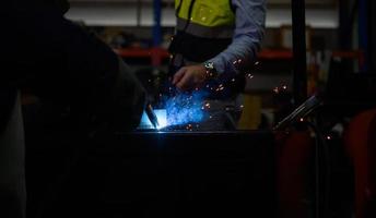 soldador trabajando metal de soldadura con ingeniero para controlar de cerca el trabajo a fin de obtener la calidad de acuerdo con la forma prescrita. foto