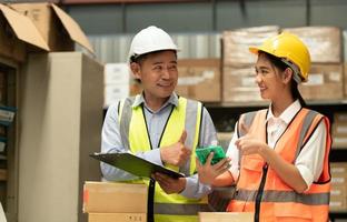 Warehouse Manager with female assistant Rethink a plan to prepare items that need to be sold to retailers during times of higher market prices. photo