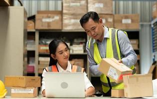 Warehouse Manager with female assistant Rethink a plan to prepare items that need to be sold to retailers during times of higher market prices. photo