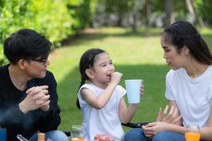 Family holiday activities include father, mother and children with camping barbecue and play in the yard together happily on vacation. photo