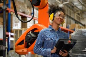 A young female worker is controlling a mechanical robot. to sort out the items that come into the warehouse to wait for the next shipment. photo