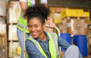 Two girls warehouse workers relax and play during the break of the day. photo