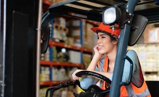 Portrait of an Asian woman with a forklift used to lift heavy objects in a warehouse. photo