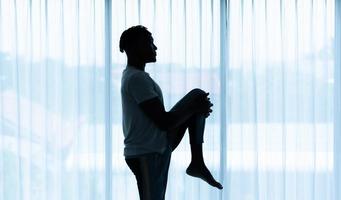 joven africano haciendo ejercicio de yoga en el salón de su casa con el placer de relajarse con deportes ligeros en el ambiente matutino del día. foto