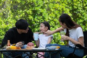 las actividades de vacaciones familiares incluyen padre, madre e hijos con barbacoa para acampar y jugar juntos en el patio felizmente de vacaciones. foto