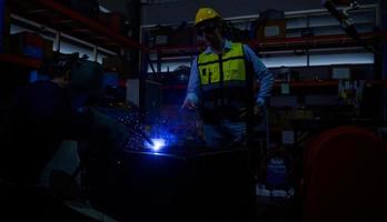 Welder working welding metal with Engineer to closely control the work in order to obtain the quality according to the prescribed form. photo