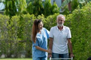 Doctors are helping senior patients learn to walk and exercise in the lawn of the house. photo