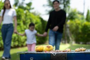 las actividades de vacaciones familiares incluyen padre, madre e hijos con barbacoa para acampar y jugar juntos en el patio felizmente de vacaciones. foto